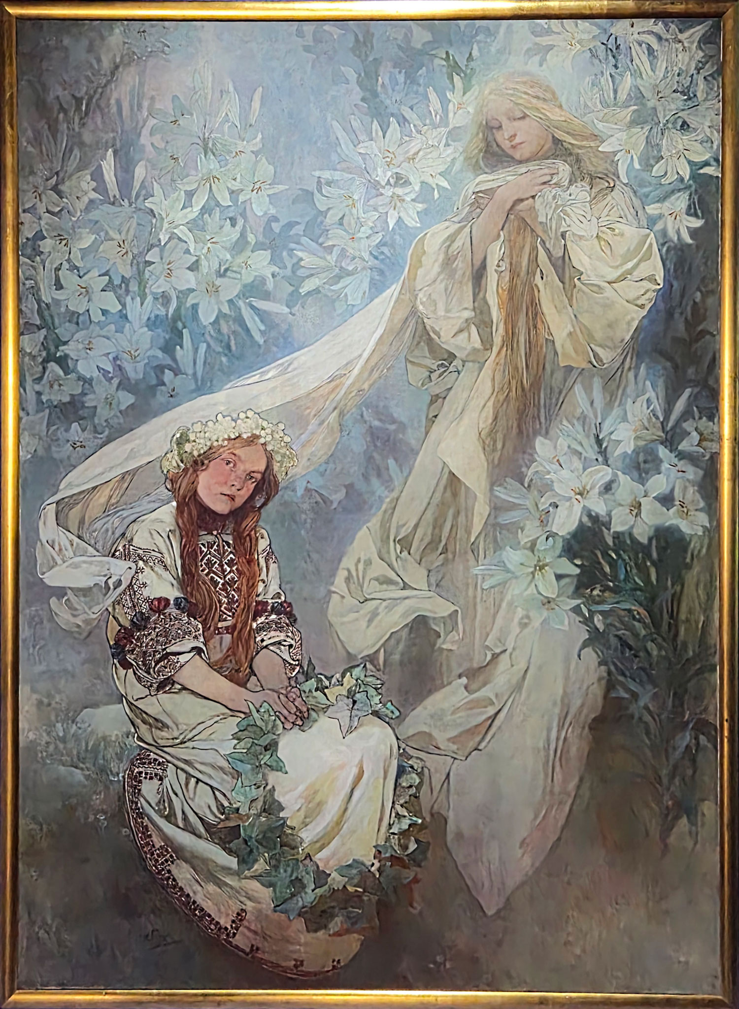 백합의 마돈나(Madonna of the Lilies) 1905체코의 국보인 이 작품은 본래 예루살렘의 성당 벽화로 기획되었기 때문에 세로 약 2.5m, 가로 약 1.8m에 달하는 대형 크기로 제작되었다. 의뢰는 받았으나 알 수 없는 이유로 나중에 취소되었고 그 중 이 작품의 초기 버전들과 스테인드글라스 디자인인 '조화'만이 남아 있다고 한다. 이 작품의 주제는 '순결한 처녀(Virgo purissima)', 순수함을 상징하는 백합꽃에 둘러싸인 천상의 마돈나를 묘사했고 화면 아래엔 슬라브 전통 의상을 입은 앉아 있는 어린 소녀는 기억을 상징하는 담쟁이 잎 화관을 들고 있는 장면을 담았다. 소녀의 진지한 표정과 신비로운 성모의 강렬한 존재감은 서로 대조를 이룬다. This Czech national treasure was originally intended as a mural for a cathedral in Jerusalem, and was therefore produced in a large scale, approximately 2.5 meters high and 1.8 meters wide. The commission was later canceled for unknown reasons, and only early versions of the work and the stained-glass design 